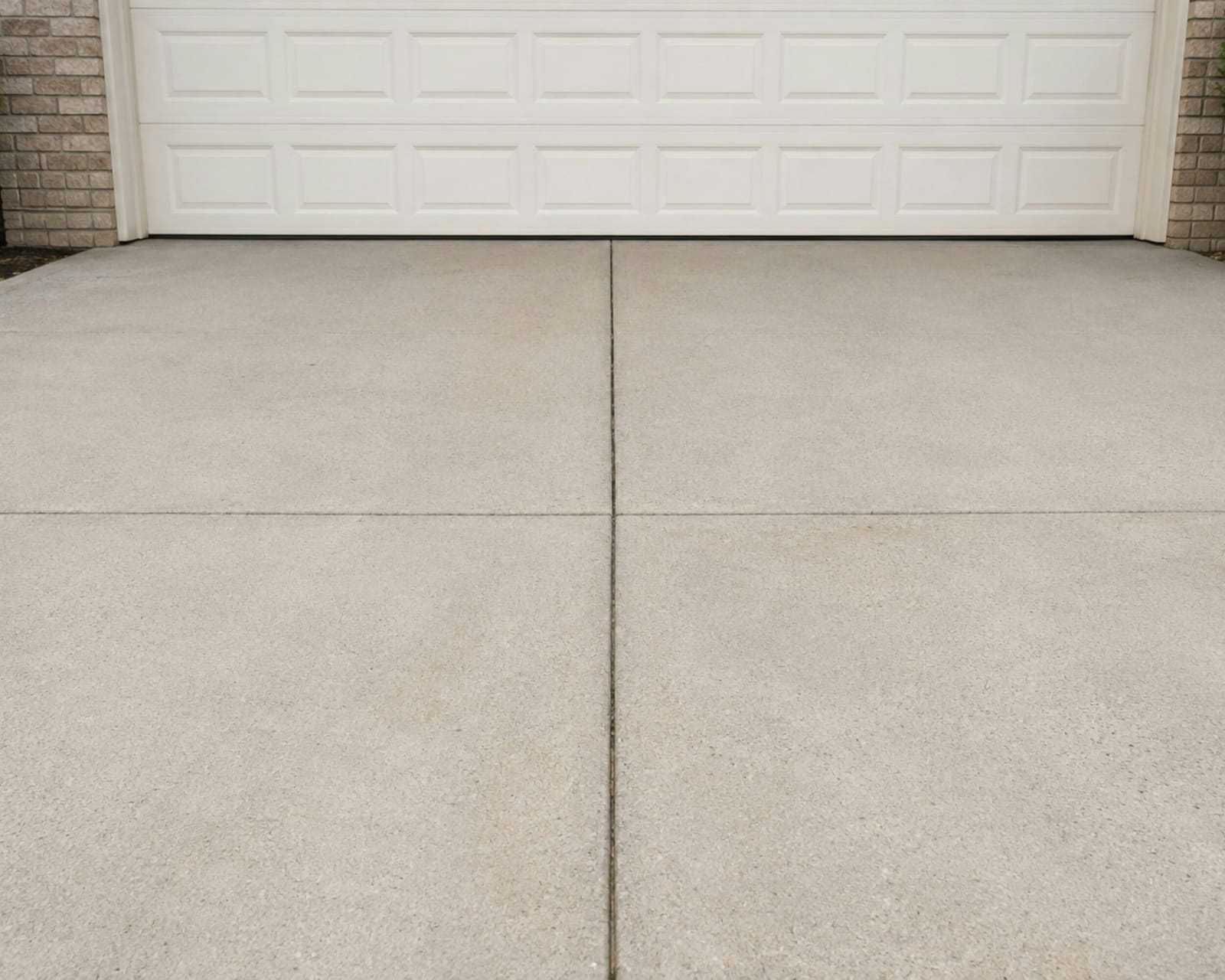 AI-generated illustrative image of a smooth, freshly finished concrete driveway leading to a garage